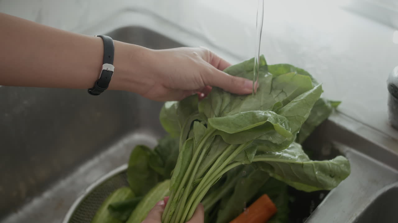 Hands of Person Washing Greenery at Kitchen Sink