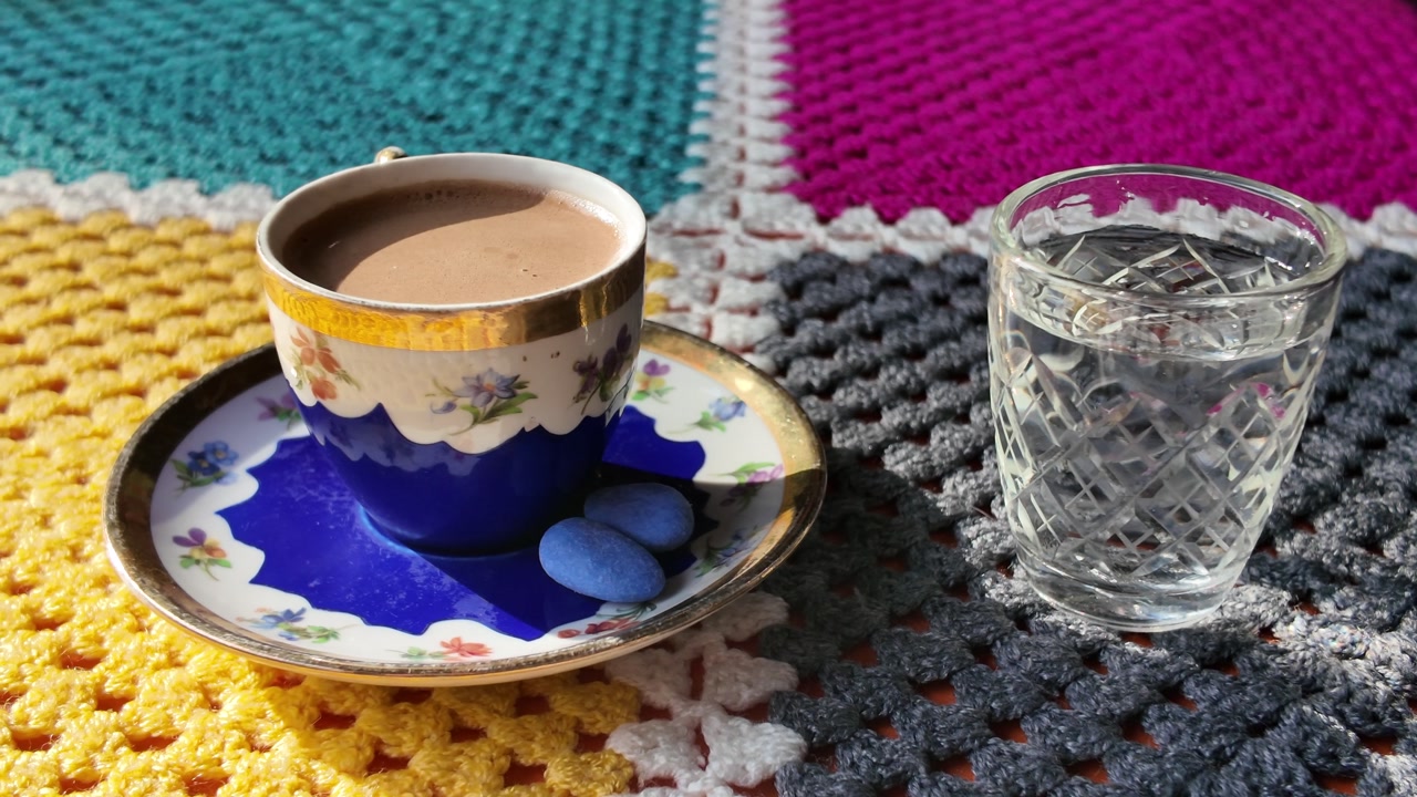 Vintage Coffee Cup and Water Glass on a Colorful Crocheted Blanket