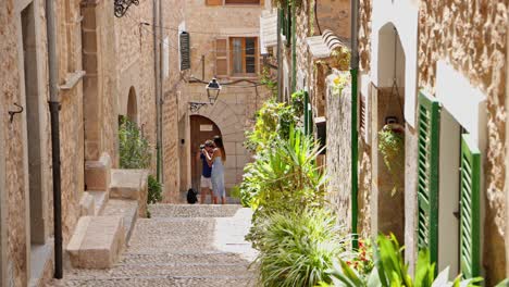 pair are taking pictures sidewalk at valldemossa, highest village at mallorca