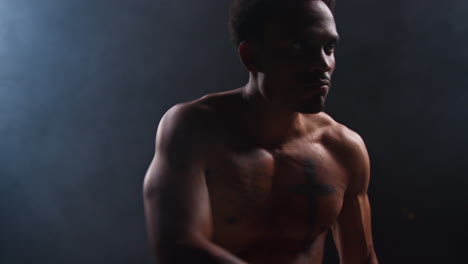 hombre muscular posando en un estudio con humo