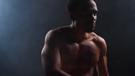 muscular man posing in a studio with smoke