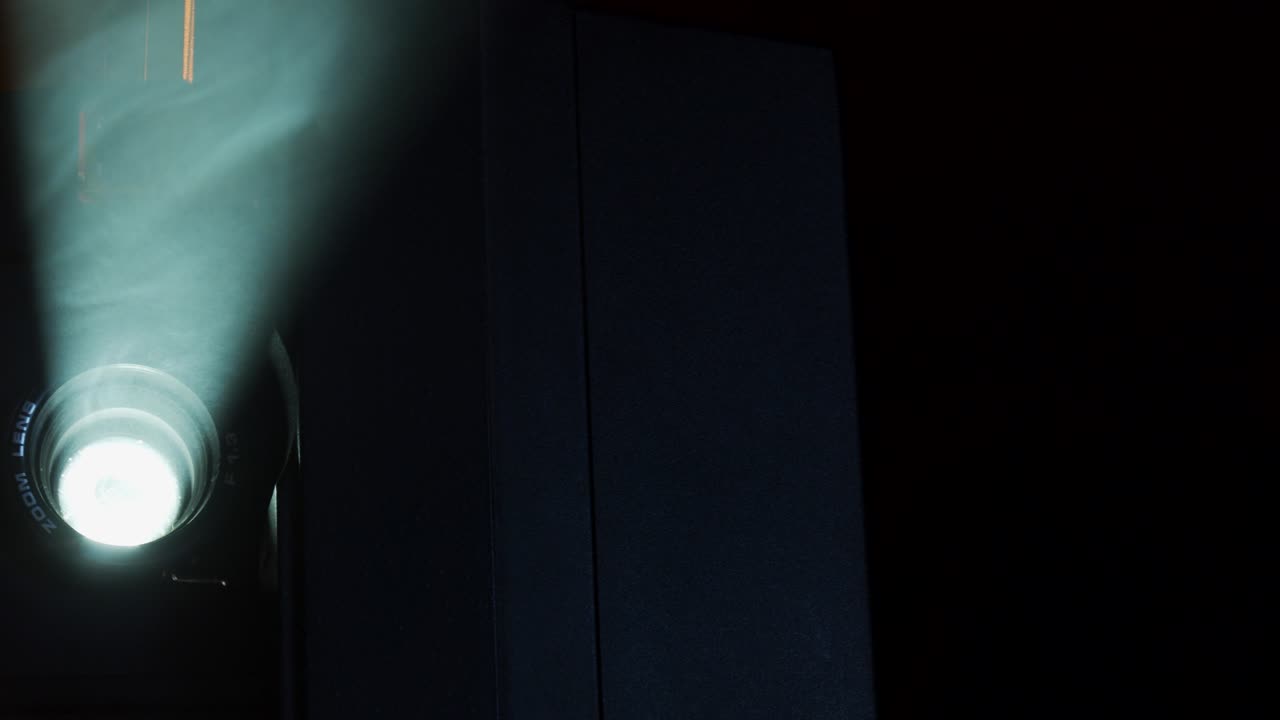 Super-8 movie projector shows old home movies in a smokey room