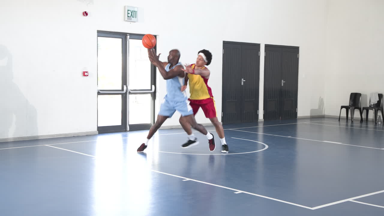 Practicing dribbling skills, basketball players focused and determined on school court