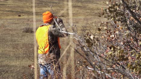 hunter walks by tree and looks through binoculars