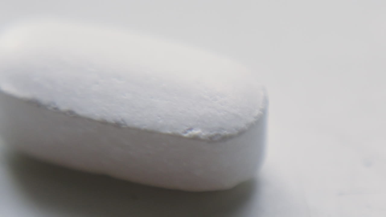 Macro ravvicinato di una compressa di magnesio. Pillola per il benessere come supplemento per una dieta sana. Ideale per spiegazioni sanitarie, contenuti farmaceutici e di benessere. Settore degli integratori biologici