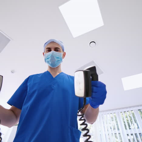 three doctors holding medical instruments in the emergency room. medical specialists in blue uniform with masks using medical tools to give resuscitation to a patient in clinic.