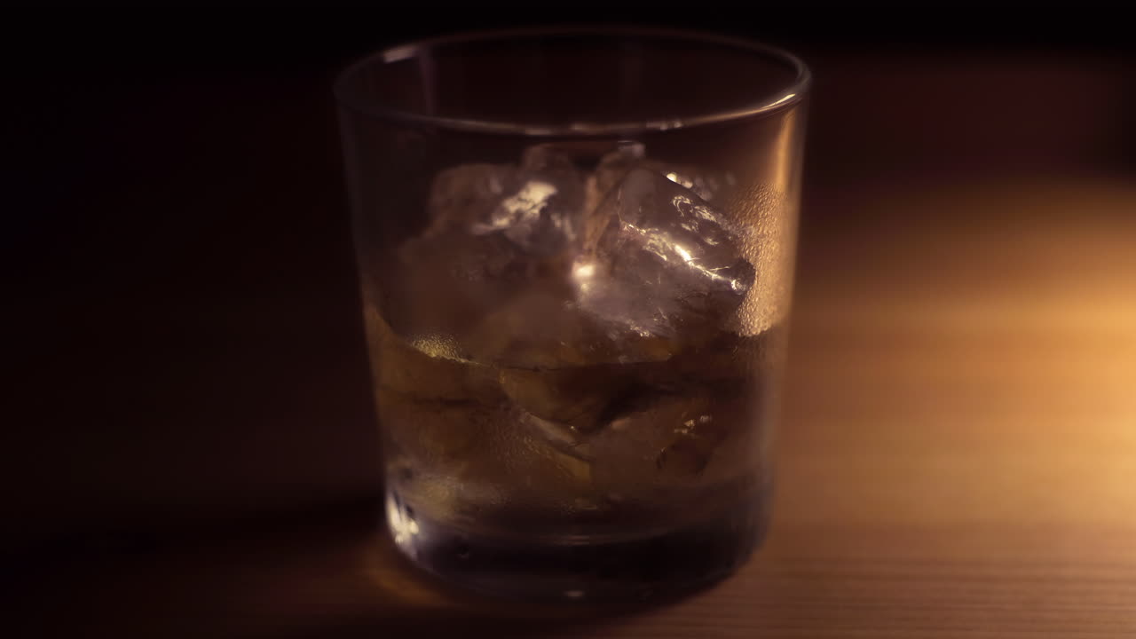 un vaso de whisky, bourbon o ron en las rocas, ver el hielo derretirse con este metraje de lapso de tiempo