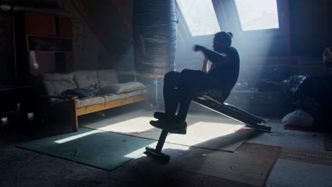 man working out in an attic home gym