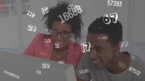 digital composition of multiple changing numbers floating against man and woman using computer