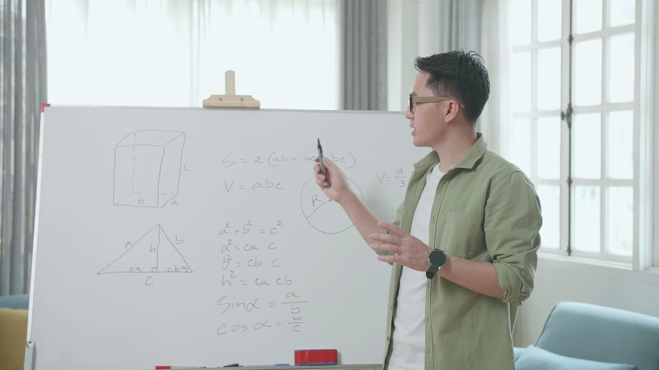 Asian Male Teacher With Glasses Teaching Math At Home