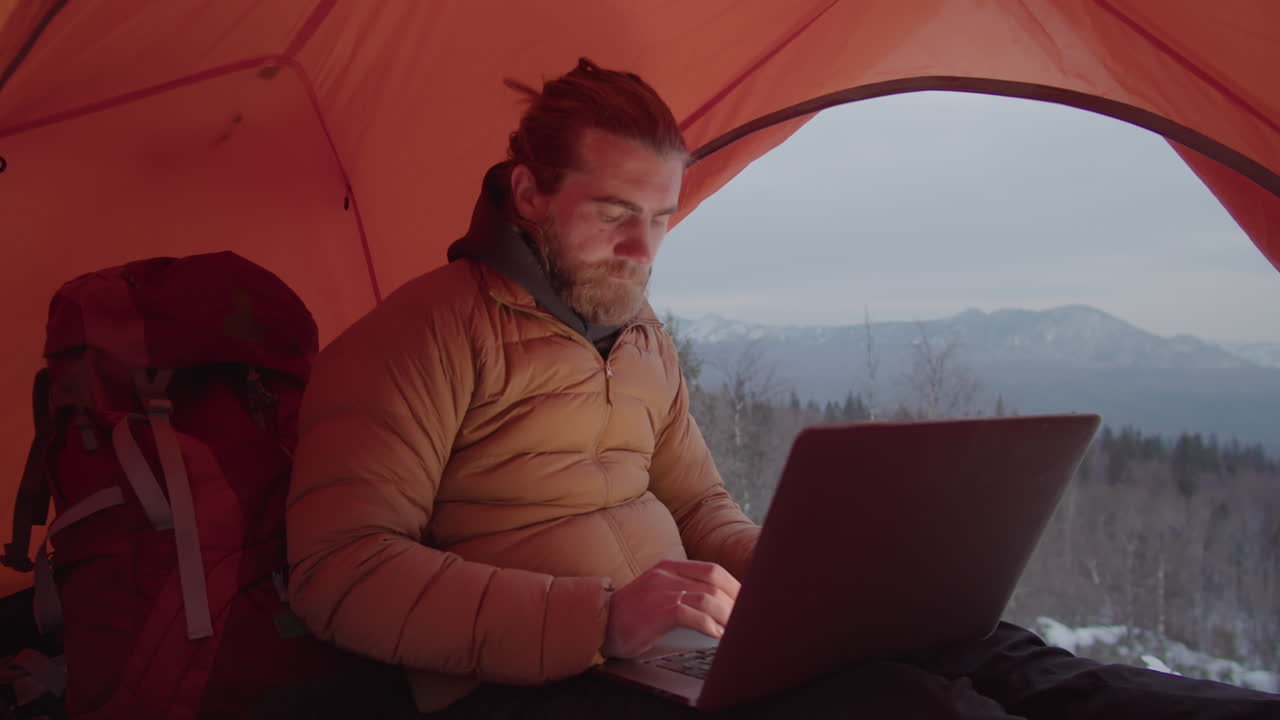 Tourist Using Laptop in Camping Tent in Mountains