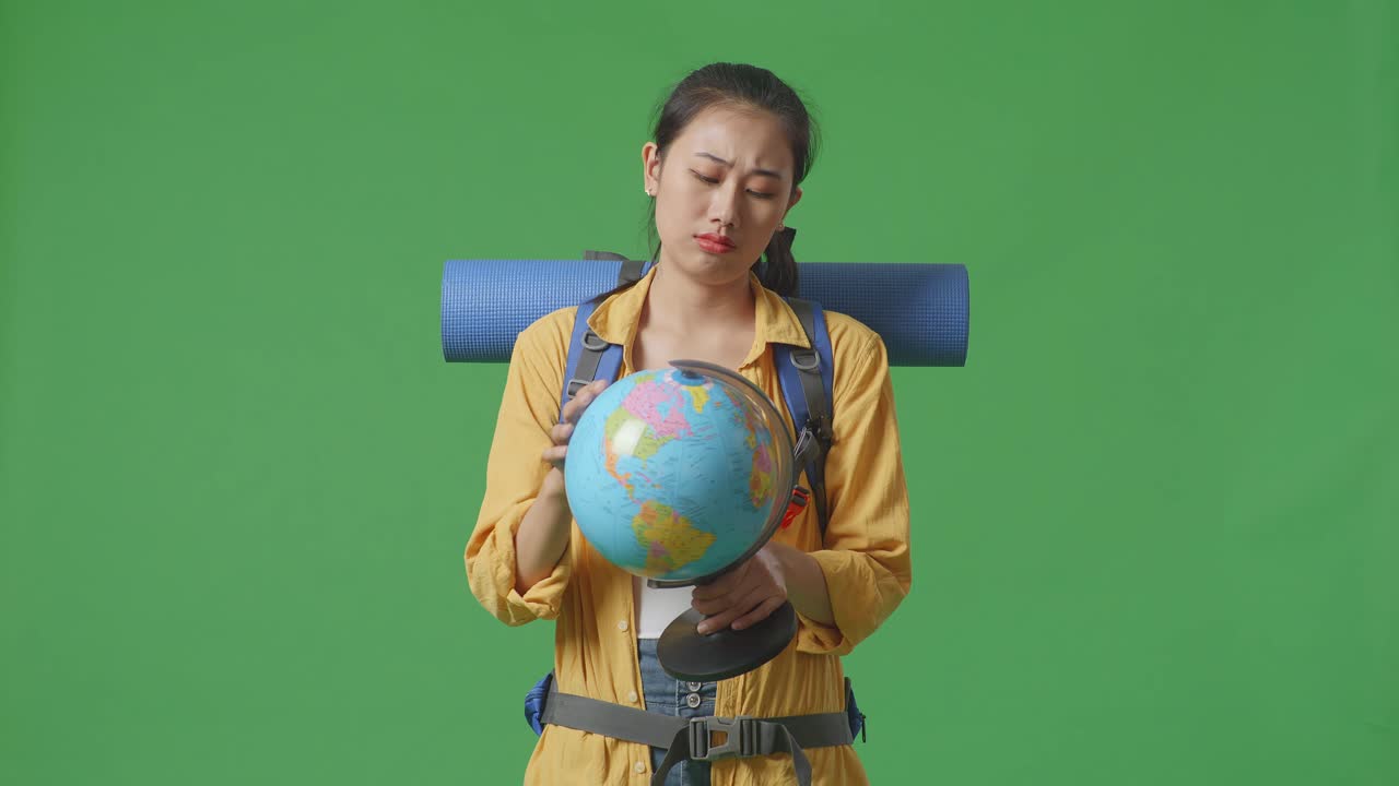 mujer con mochila mirando un globo