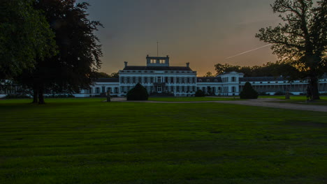 beautiful time lapse of the sun setting behind a imposing palace in the netherlands