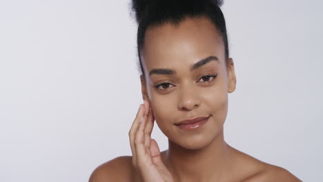 portrait attractive african american woman touching face with hands caressing smooth healthy skin complexion enjoying perfect natural beauty on white background skincare concept