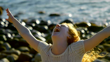 woman standing with arms outstretched in the beach 4k