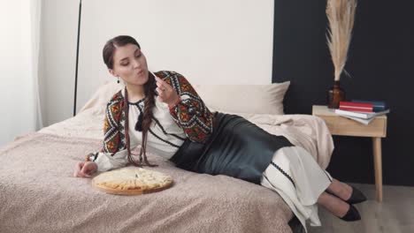 lovely-young-woman-in-embroidered-authentic-Ukrainian-attire-eats-a-cheese-platter