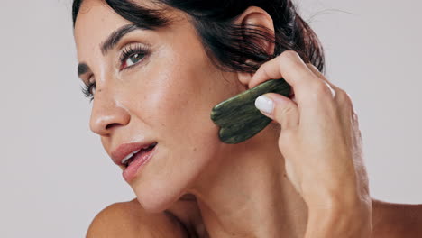 mujer disfrutando de un masaje facial de gua sha