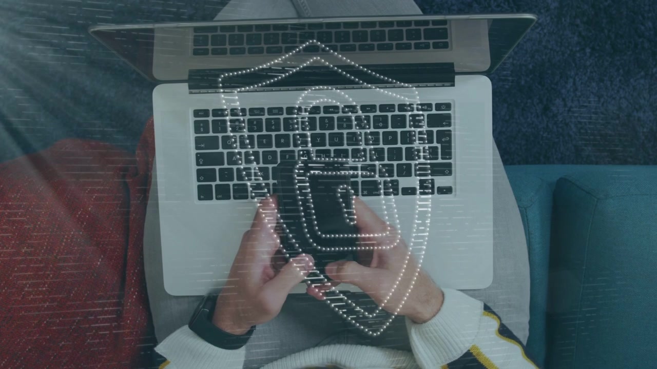 Man tapping phone above laptop on couch causing dotted shield pulsing over devices securing tech