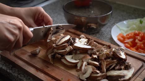 chopping uncooked portobello mushroom in the kitchen