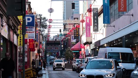 cars and pedestrians in bustling chinatown street