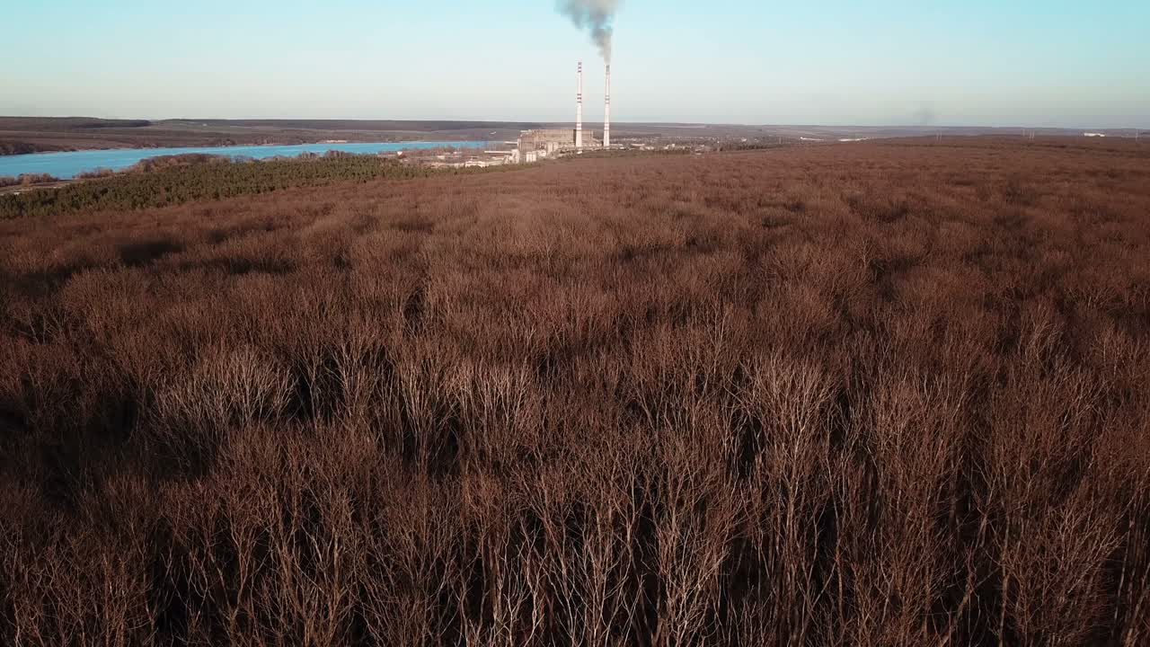 power station is working on the background of the river and the forest in the autumn. Aerial view