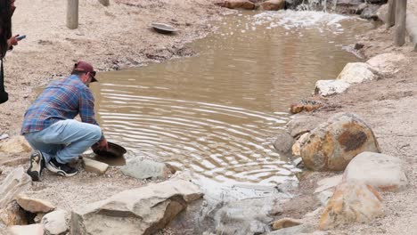 man panning for gold in a stream