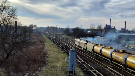 tren diésel fuera de la red tirando de camiones cisterna de petróleo en las vías del ferrocarril contaminando el aire