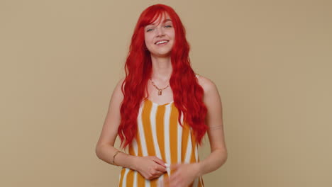 redhead young woman showing inviting gesture with hands, ask to join, gesturing hello or goodbye