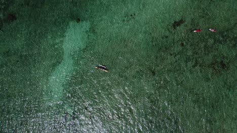 4K-cinematic-overhead-drone-shot-of-an-outrigger-boat-floating-in-crystal-clear-water-near-Kailua-Beach-in-Oahu