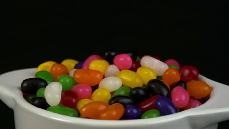 narrow depth of field: jelly bean candies rotate in bowl in dark room