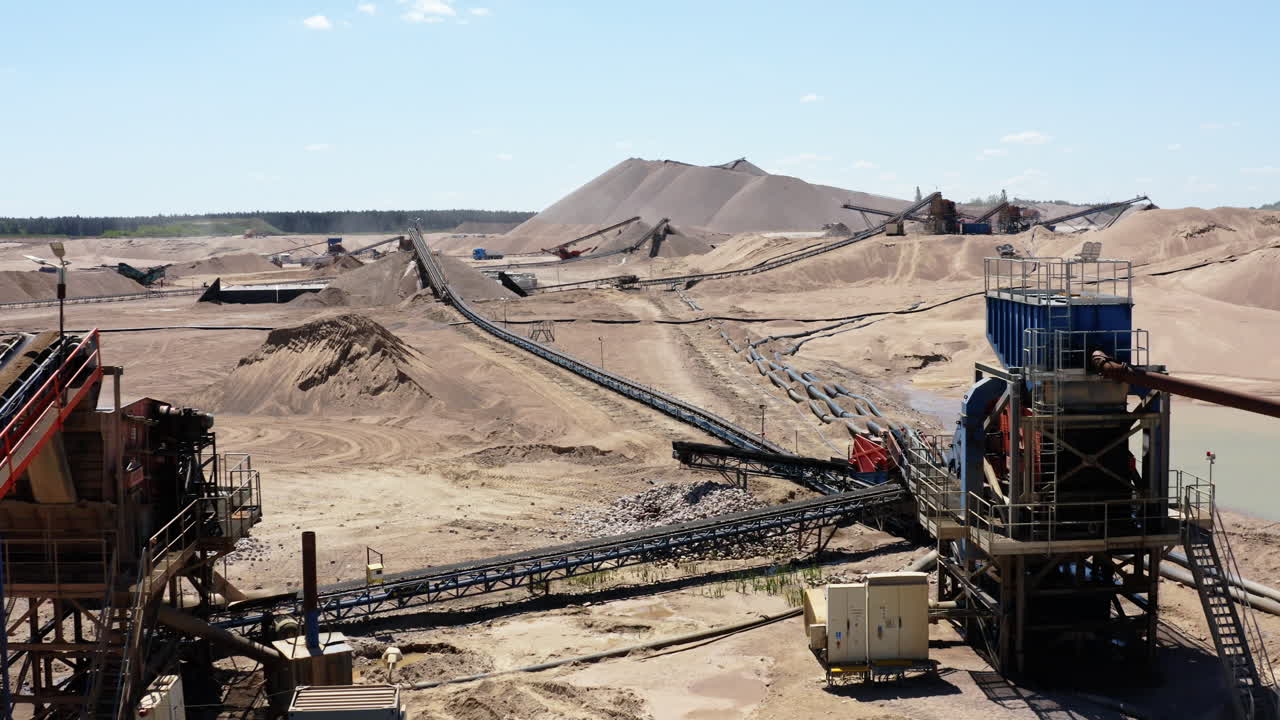 Sand And Gravel Mine With Piles Of Extracted Materials, Conveyor Belts, And Heavy Machinery. drone shot