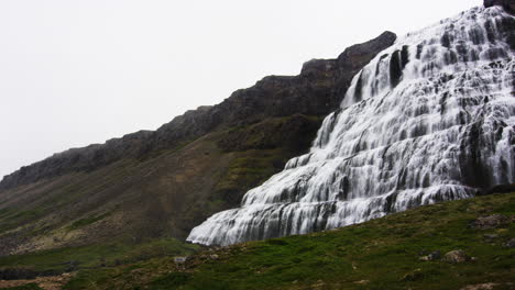 massive waterfall on mountain slope in iceland, pan right view