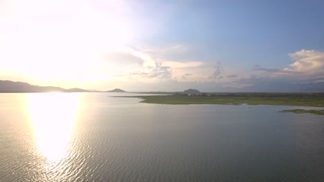 Toma-De-Drones-De-Una-Laguna-Durante-Una-Puesta-De-Sol-Con-Cielo-Despejado