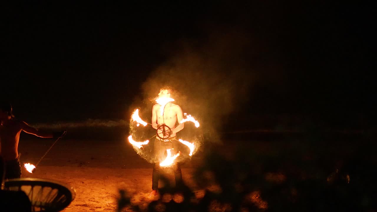 un artista muestra habilidades de fuego en la playa de krabi.