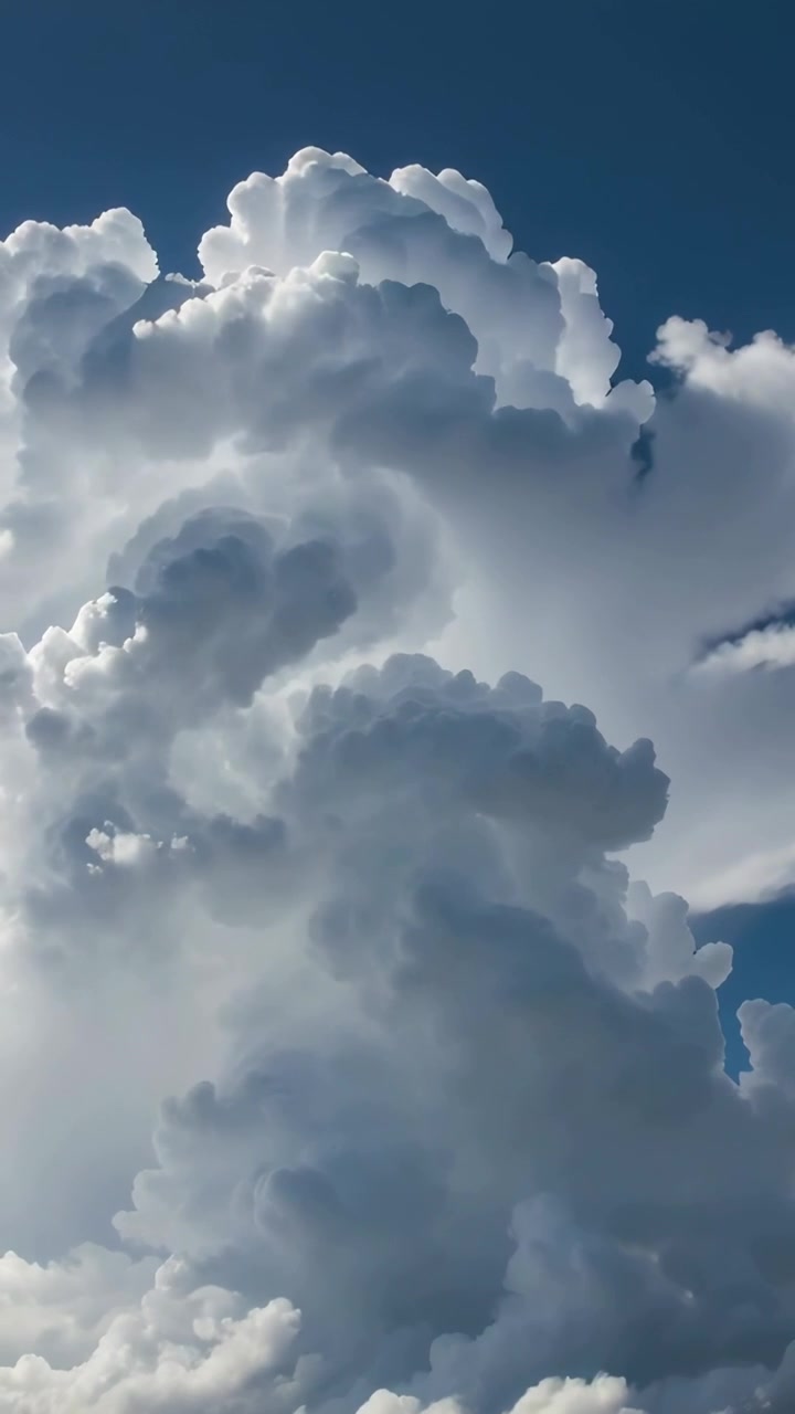Video verticale: ripresa panoramica verso l'alto che rivela imponenti cumuli contro il cielo blu, mostrando la convezione