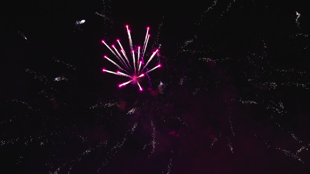 Nighttime fireworks painting the sky with vibrant glowing bursts