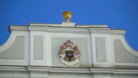 zooming in to an erb hanging on the top of the wall of an romance gothic building in czech republic golden structure on top of the roof travel documentary city town location