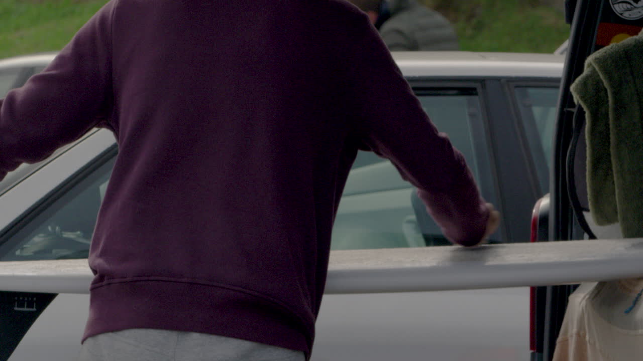 차량 트렁크 내부의 서핑보드를 청소하는 사람, 스포츠 전 준비