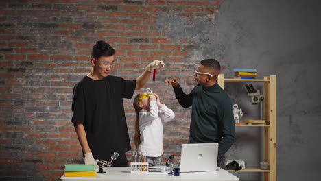 girl looks at red liquid held by teacher with black chemists