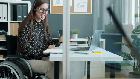 woman in a wheelchair working from home office