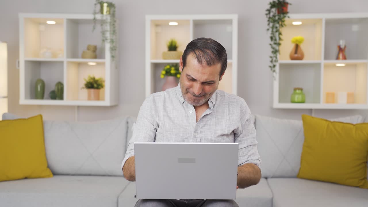 el hombre mira la computadora portátil y se alegra.