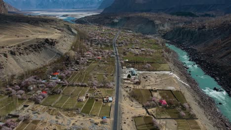 Aerial-View-Of-Valley-Floor-Beside-River-In-Skardu-With-Village-Buildings-And-Fields