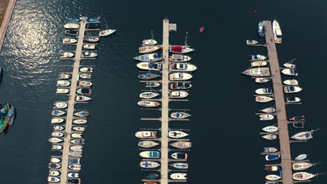 drone vista superior mirando a yates de lujo y botes a motor amarrados en la marina