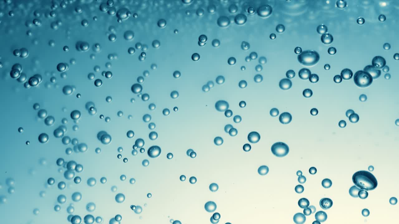 Many water bubbles in blue water close up, abstract water wave with bubbles in slow motion.