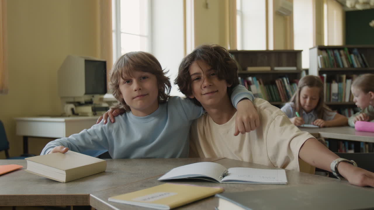 Two young boys posing together in a classroom or library