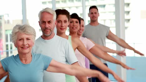 yoga-klasse streckt ihre arme aus