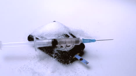 Syringe-falling-onto-pile-of-sugar-on-blood-glucose-monitor