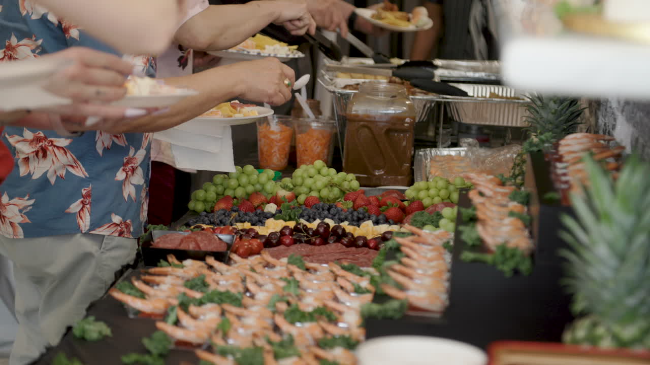 grabbing food items in a buffet line charcuterie