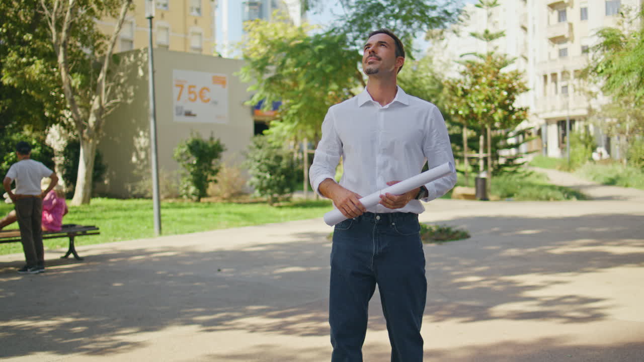 Successful engineer holding project examining houses at summer neighbourhood