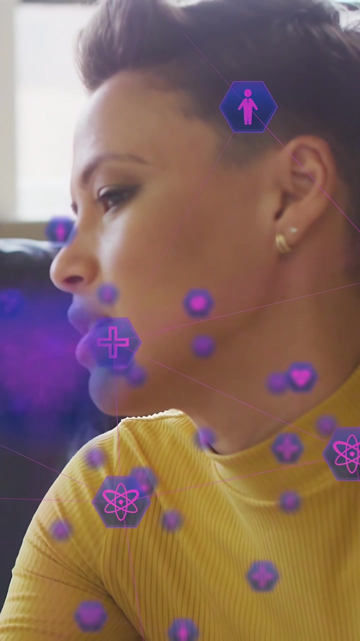 Video verticale: Donna che parla a un collega, con icone esagonali AR che fluttuano sul viso mostrando dati tecnologici.